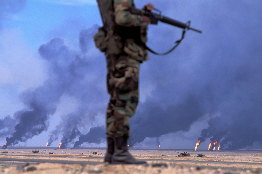 KUWAIT. 1991. Safwan. US soldier in front of oil wells in fire.