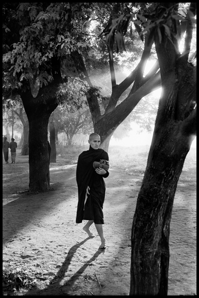 MYANMAR. Mandalay. 2009. At dawn a monk goes begging for alms.